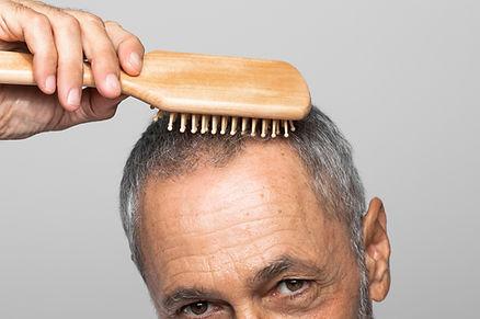 A man holding a comb on his head