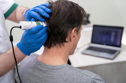 A surgeon is doing scalp examining.